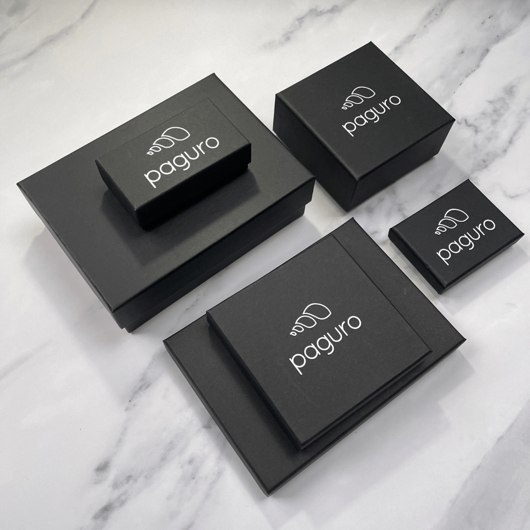 Paguro Upcycle black jewelry boxes for recycled rubber bracelet displayed on marble surface
