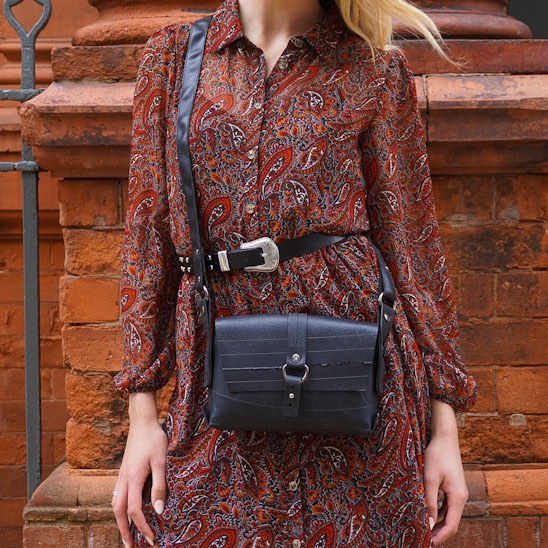 Paguro Upcycle black vegan handbag worn crossbody with textured design and buckle detail