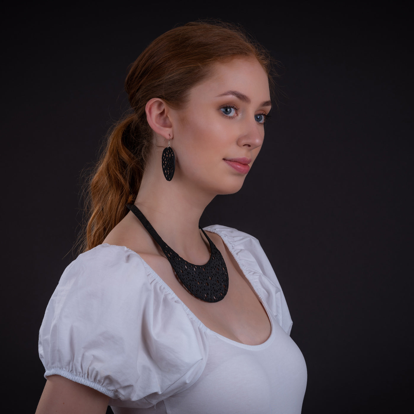 Paguro Upcycle upcycled inner tube necklace and matching earrings black textured crescent pendant on model