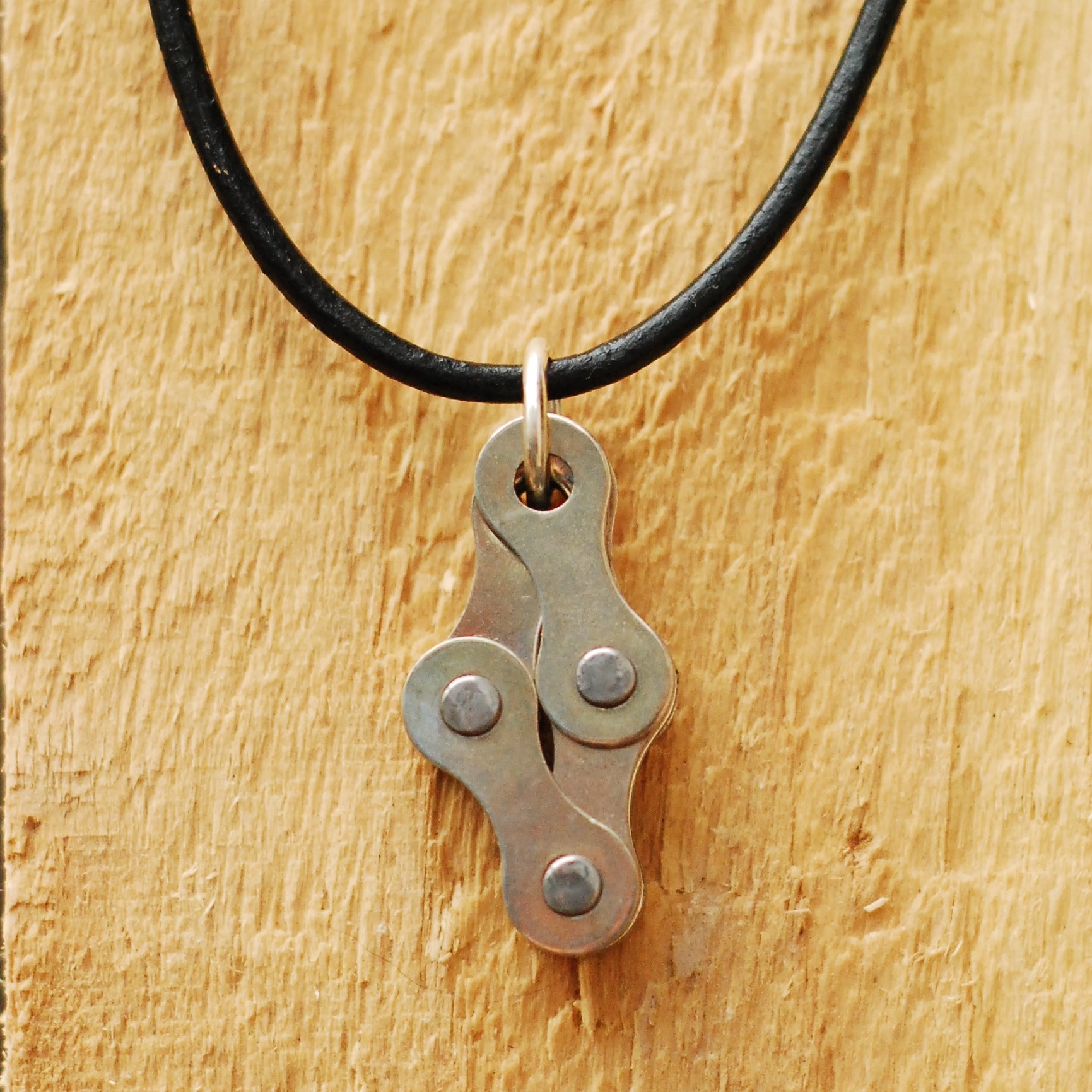 Paguro Upcycle recycled bike chain necklace pendant on black leather cord showing upcycled bike link design