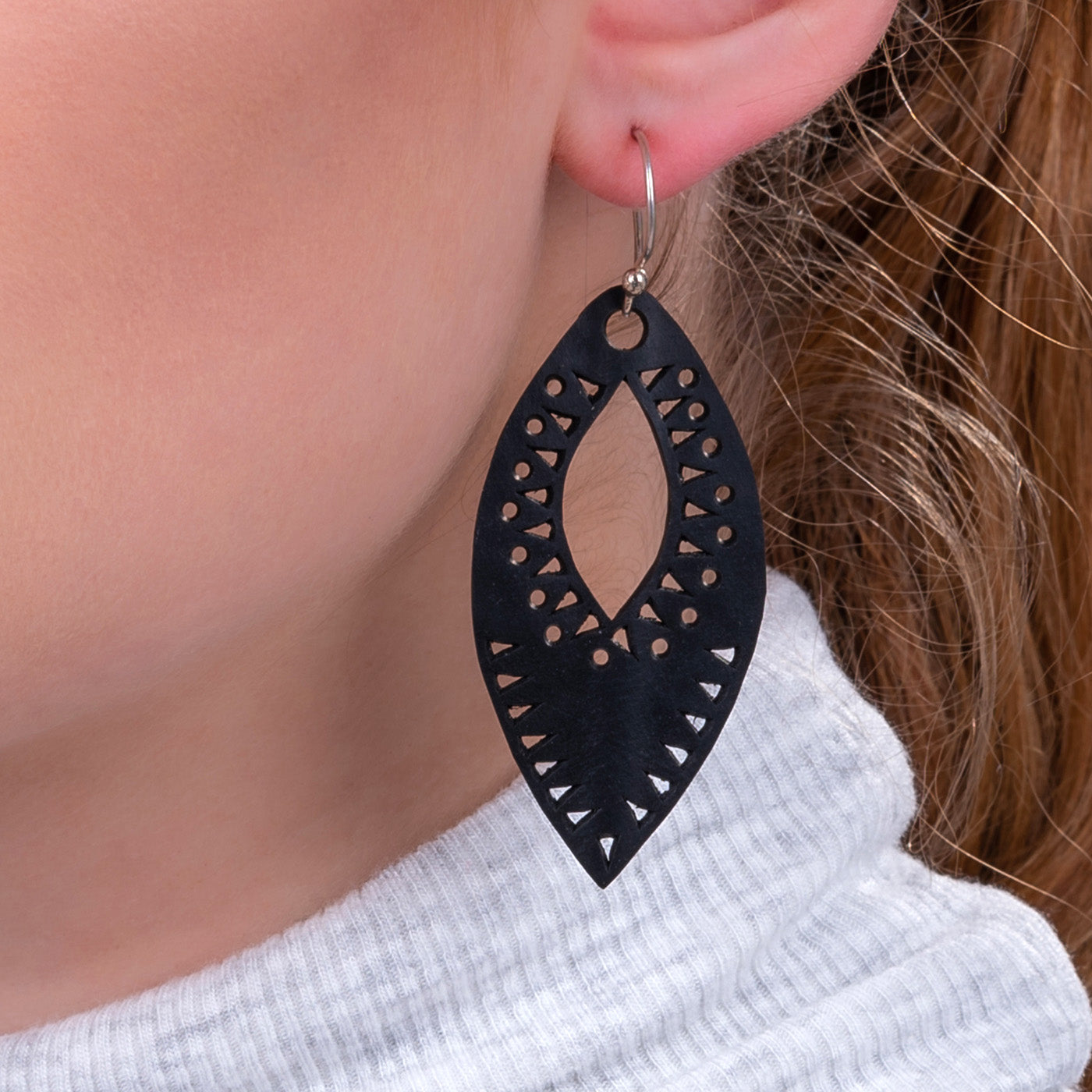 Paguro Upcycle black recycled rubber earrings with geometric cutout design worn on ear