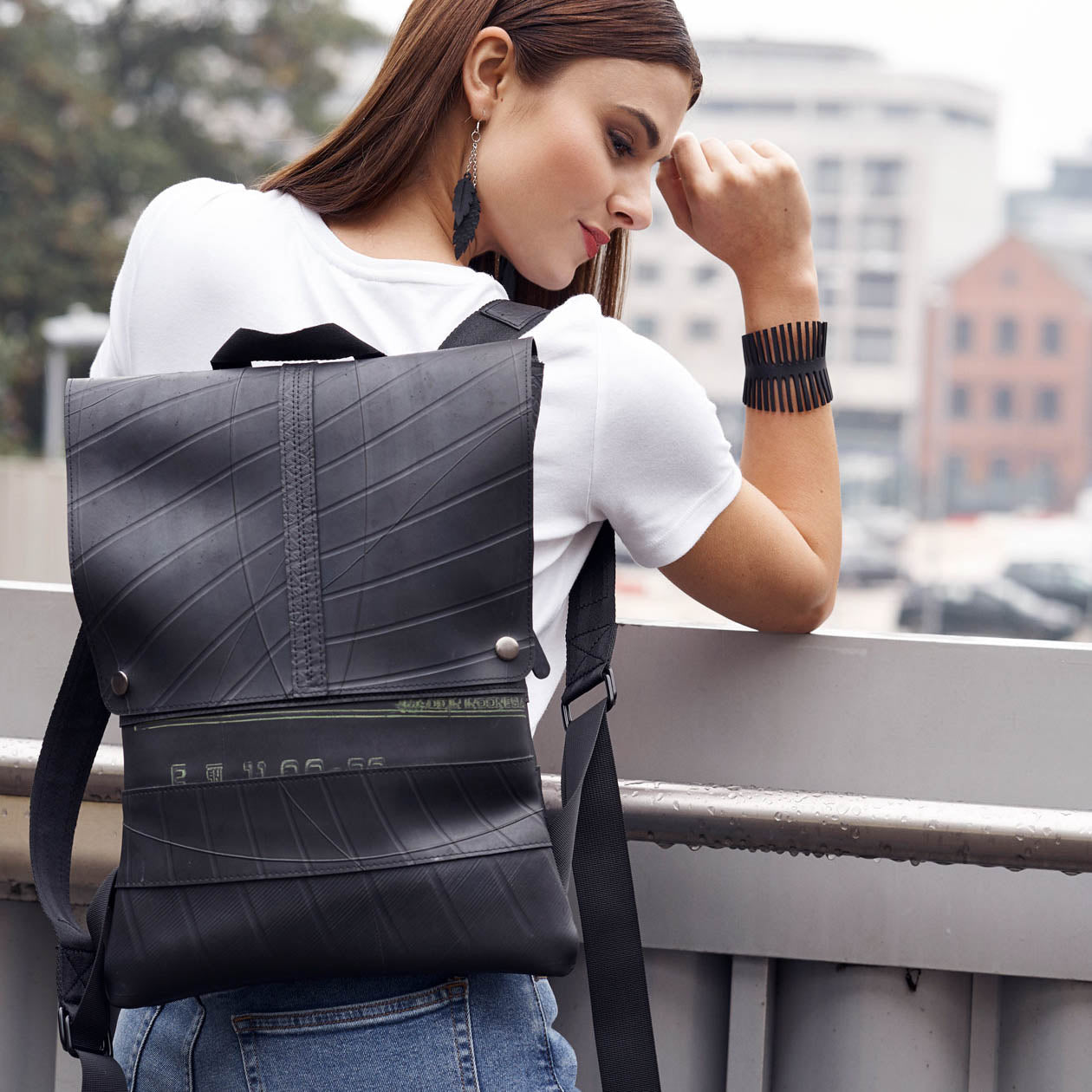 Woman wearing black vegan inner tube backpack by Paguro Upcycle in an urban setting